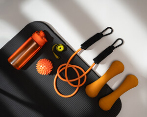 Variety of fitness equipment on a yoga mat