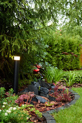 A Serene Garden Landscape that Features Beautiful Lighting and Decorative Rocks Elements