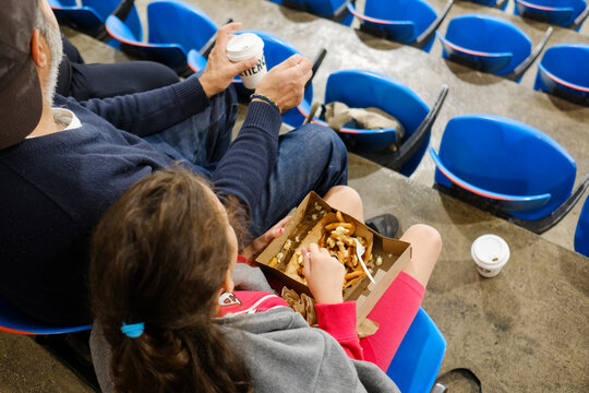 Unrecognizable audience in arena eating on grandstand