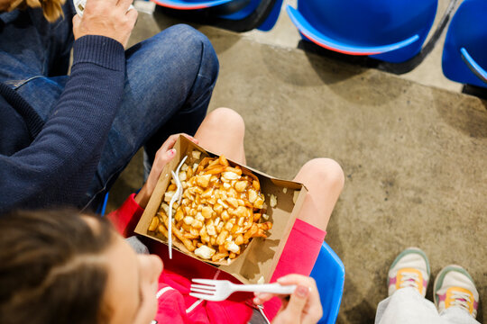 Unrecognizable audience in arena eating on grandstand