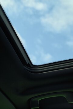 Blue sky through a car sunroof