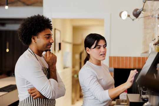 Cashier entering order on touchscreen at cafe