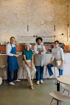 Team of restaurant workers posing in front of restaurant counter