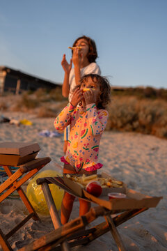 Siblings eating fish and chips at the beach