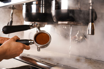 Professional brewing, coffee bar details. Espresso coffee pouring from espresso machine. Barista details in cafe.