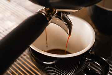 Brewing espresso in to glass cups silver coffee espresso machine white and clean interior. Barista working with coffee machine and making espresso coffee, speciality coffee black arabica.