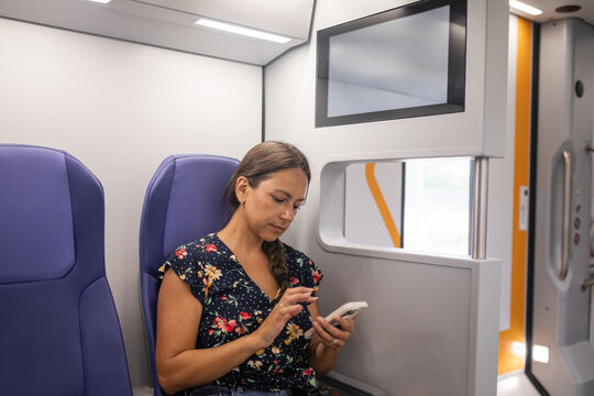 woman traveling by train using phone
