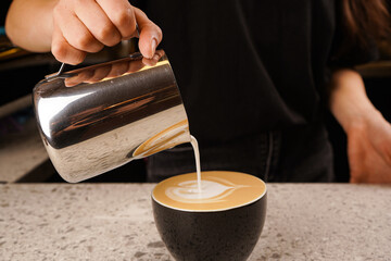Close-up of the process of brewing cappuccino coffee with thick milk foam from the cappuccinatore.