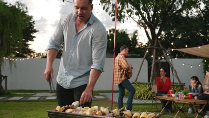 Family camp in garden, Father help old couple grill food for family member. Outdoor camping...