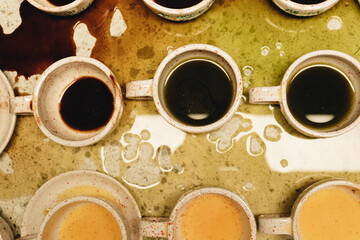 Dark coffee spots spread unevenly on the surface, the drops sparkle in the light, adding to the...