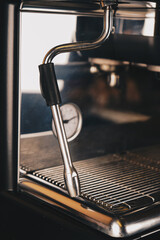 Close-up image of a coffee machine that works automatically. The aroma of coffee pervades the entire workshop and the atmosphere of the store looks warm.