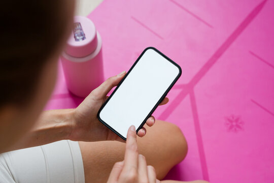 Woman using smartphone with white screen after fitness training