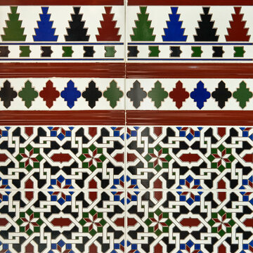 Fragment of building wall with glazed ceramic tiles, embossed vintage Mudejar, close up. Traditional ornate Spanish architecture. Abstract background, textured ornate pattern for design or backdrop.
