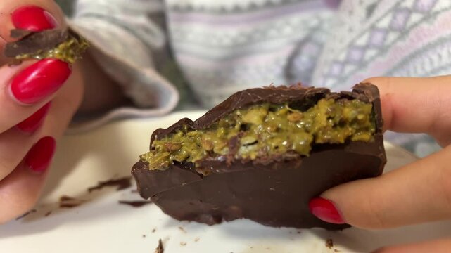 Dubai chocolate close-up detail. Dubai chocolate with liquid peanut butter and kadaif. Dubai chocolate with green kadaif and peanut butter isolated on white background. Aleppo desserts.