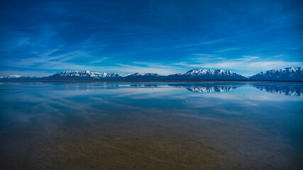 MARCH 2024, GREAT SALT LAKE, UTAH - Bridger and Farmington Bay's are featured on Antelope Island State Park, Utah surround by Wasatch Mountain Range with snow