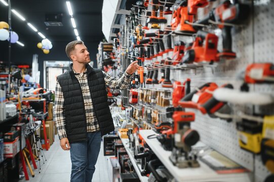 A man chooses a power tool in a hardware store