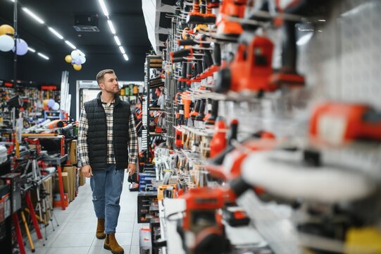 A man chooses a power tool in a hardware store