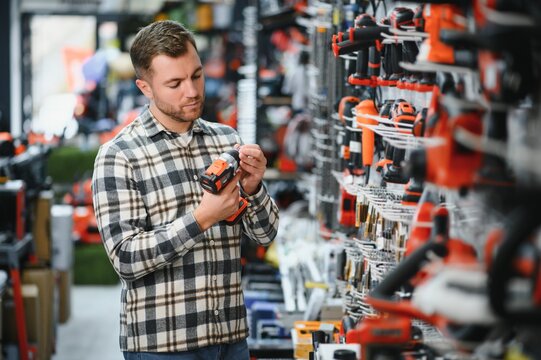 A man chooses a power tool in a hardware store