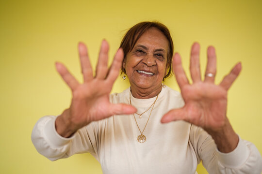 Senior woman hands outstretching her hands in a studio portrait