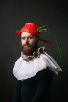 Portrait of a man with a red kitchen ladle on his head.