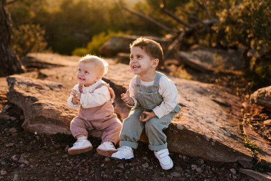 Toddler Pointing While Baby Sister Claps Hands