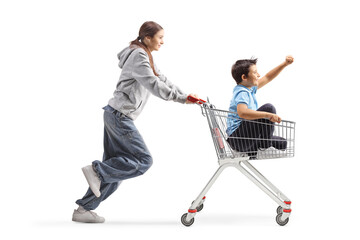 Sister pushing her younger brother in a shopping cart