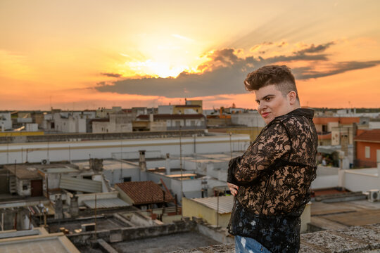 Non-binary person portrait on the roof at sunset