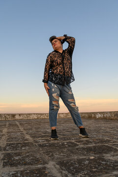 Expressive non-binary person dancing on the roof
