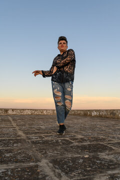 Expressive non-binary person dancing on the roof