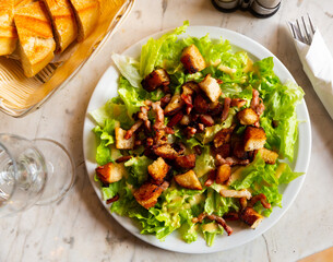 French cuisine, traditional homemade Salade aux lardons - salad with bacon, crackers and lettuce