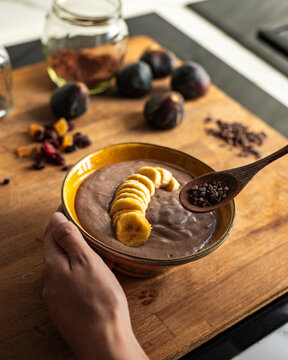 Woman Adding Cacao Nibs to Smoothie Bowl