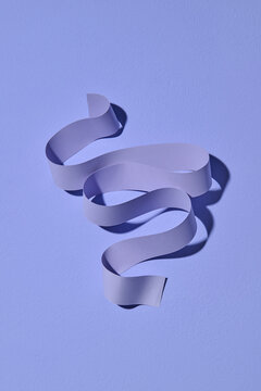 Elegant Purple Ribbon Beautifully Curled on Soft Lavender Surface