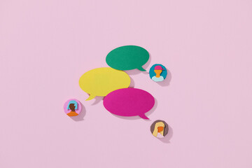 Colorful Speech Bubbles and People Icons on Pink Background