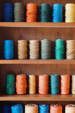 Colorful Spools of Twine on Wooden Shelves