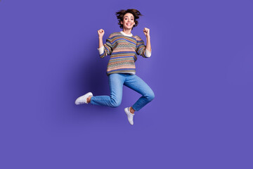 Photo of overjoyed glad nice woman wear trendy clothes jump up rejoice isolated on purple color background