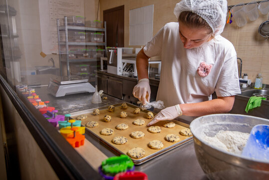 Female Baker makes cookies in the bakery