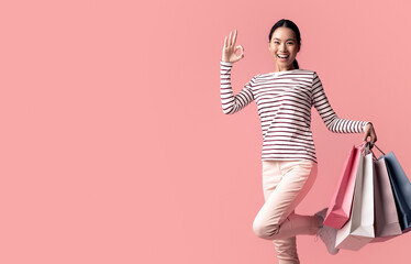 Big Sales Concept. Happy Asian Female Jumping With Shopping Bags And Showing Ok Gesture, Excited Young Korean Woman Enjoying Seasonal Discounts, Posing Isolated Over Pink Background, Copy Space