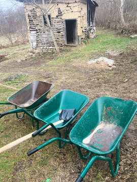 Wheelbarrows against an old barn.