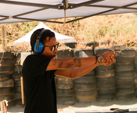 African man Shooting guns at gun range