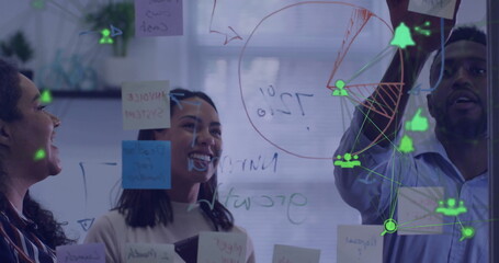 Image of network of media icons over diverse male and female colleagues brainstorming at office