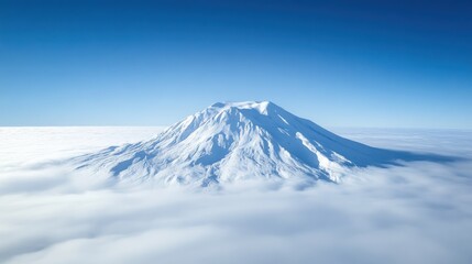 A photo of an isolated snow covered volcano taken from the air, with a clear blue sky and white clouds below it