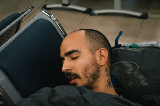 Man sleeping on airport chairs 