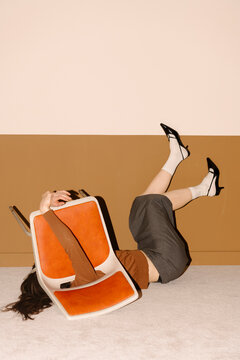 Funny Moment of Woman Tripping Over Orange Chair