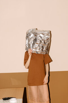 Mysterious Figure with Foil Mask Standing Indoors