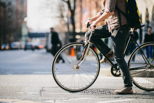 Person Riding a Bicycle on Busy Urban Street