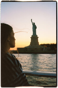 Analog mid-range of female traveler gazing at the Statue of Liberty