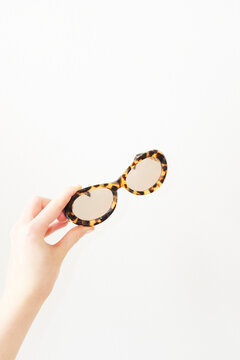 Hand holding fashion style leopard animal print sunglasses with flash