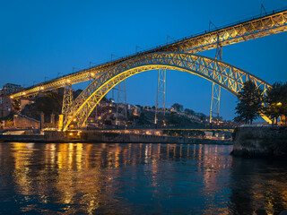 Fototapeta premium The iconic Dom Luís I Bridge, illuminated against the night sky, stands as a symbol of Porto s industrial heritage and architectural beauty.