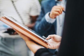 A group of multicultural business people engages in an outdoor meeting in a city setting,...