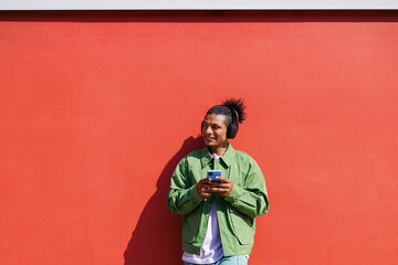 Casual man smiling while using smartphone